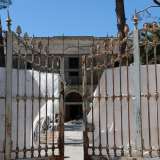 Lo stabile, di colore bianco, � preceduto da un cancello arrugginito che d� accesso a un vialetto